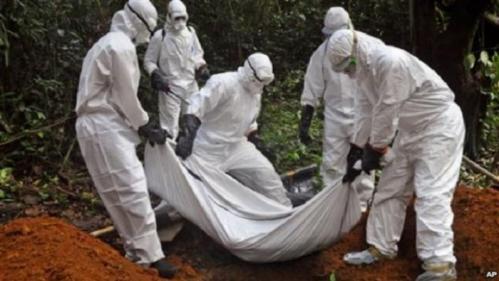 Health workers bury the body of a woman who is suspected of having died of the Ebola virus in Bomi county, Monrovia, Liberia